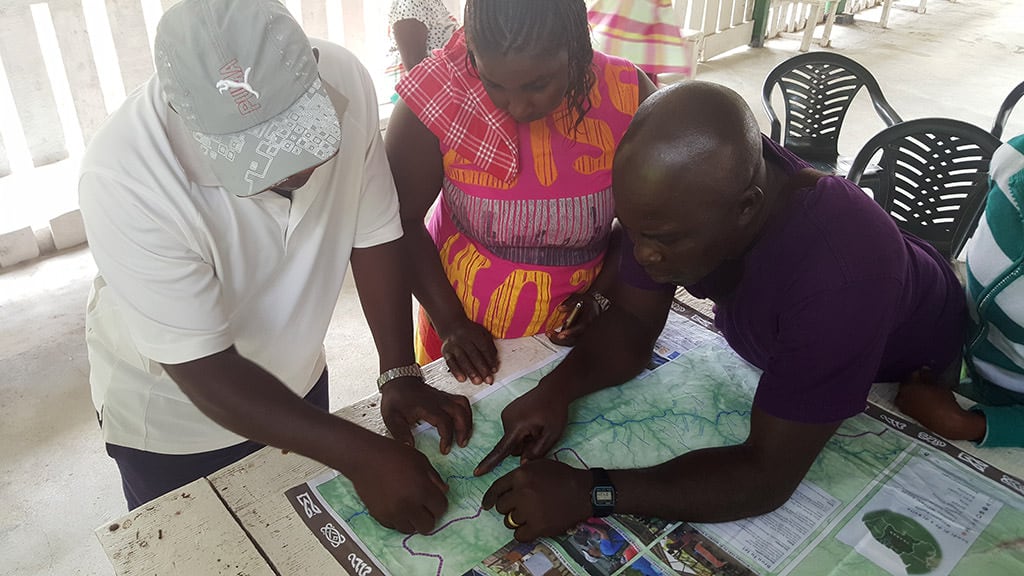 Community members examining and validating maps. Photo courtesy ACT